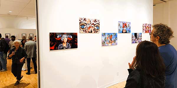 Visitors looking at the &ldquo;AI: Co-Create&rdquo; art on display