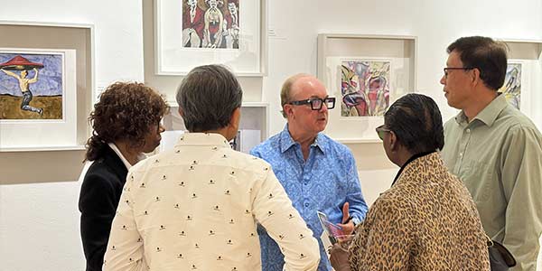 Peter Schelfhaudt speaking with a group of gallery opening attendees