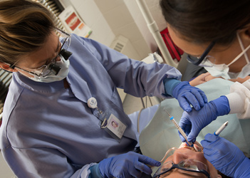 A UB student performing dental work on a patient