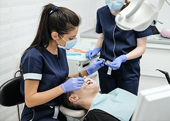 UB Dental Hygiene student with a patient