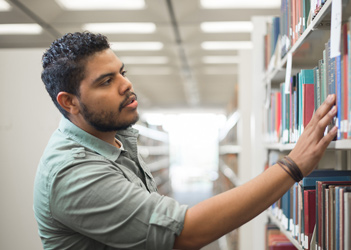 UB student looking for a book in the library