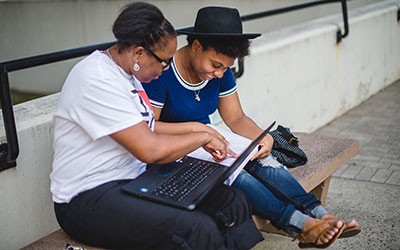 A parent with a student looking at a laptop