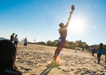 UB students playing football on the beach