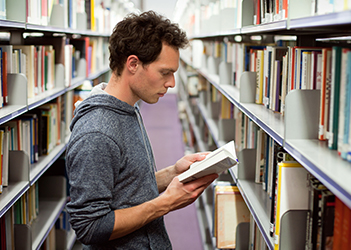 UB student reading a book in the library