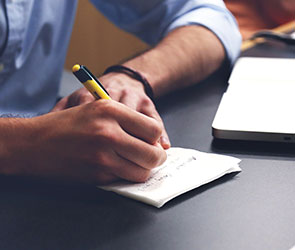 UB students writing in a notebook