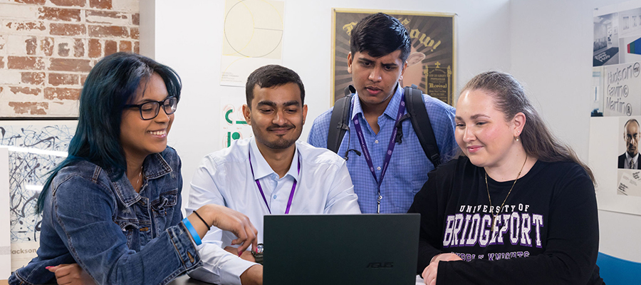 a group of people gathered around a laptop researching when should your child start applying for college?