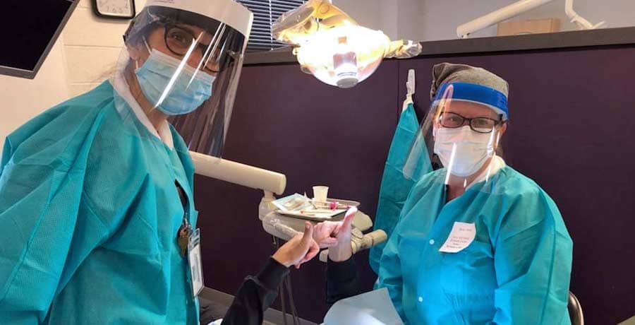 A UB Dental Hygiene student working on a patient