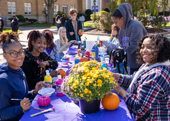 students painting pumpkins
