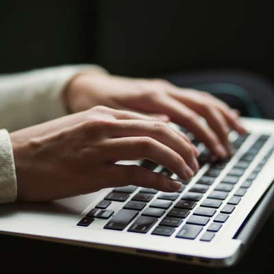 closeup of hands typing on a keyboard