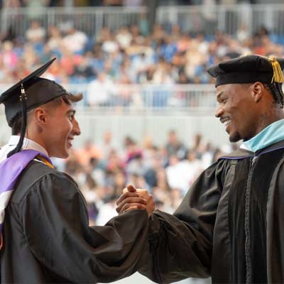 Commencement speaker Derwin James Jr congragulating a student
