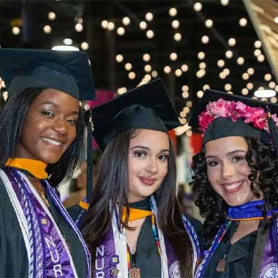 3 smiling graduates at Commencement