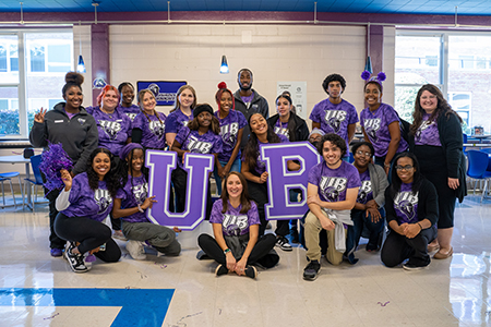 group of students wearing UB shirts holding up the letters UB
