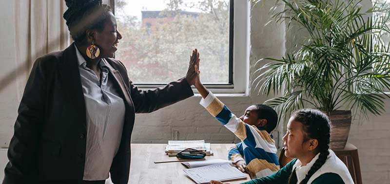 student high fiving a teacher
