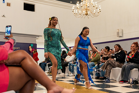 Two student-models walk down the runway at University of Bridgeport&rsquo;s &ldquo;Black is Beautiful&rdquo; fashion show