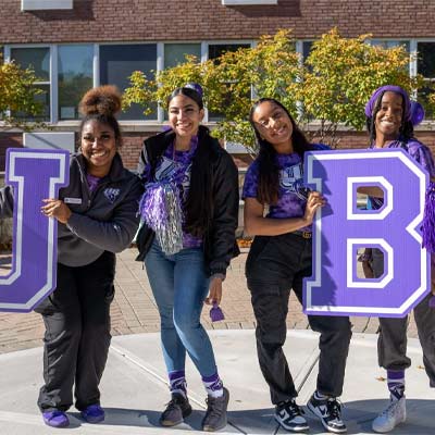 Students holding up large letters spelling out UB