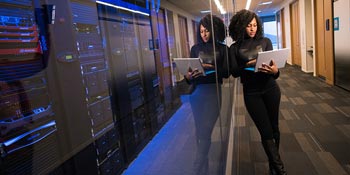 An Analytics MS student working on a laptop near servers