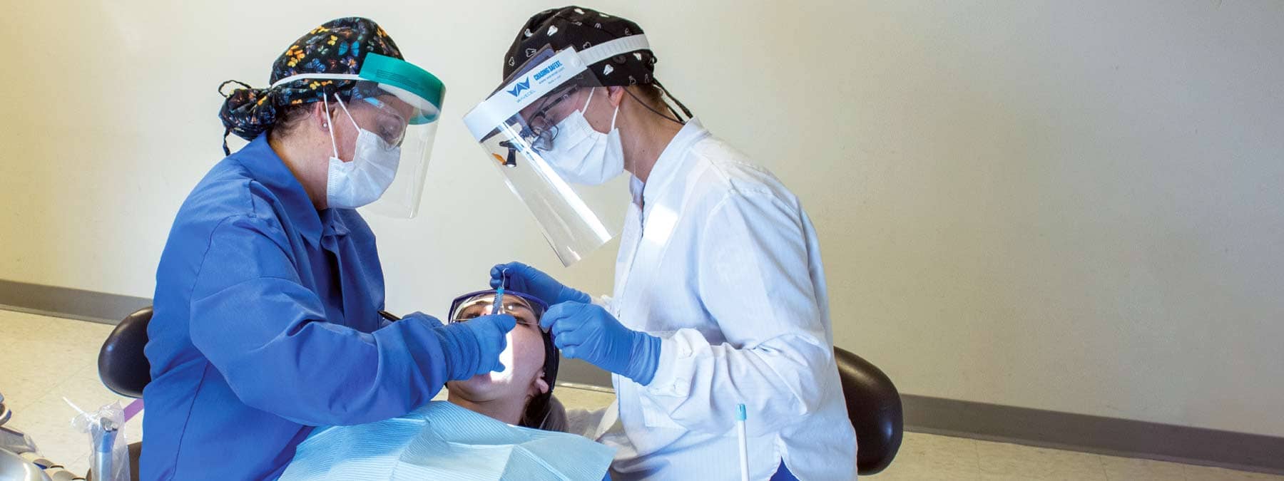 2 dental students working on a patient